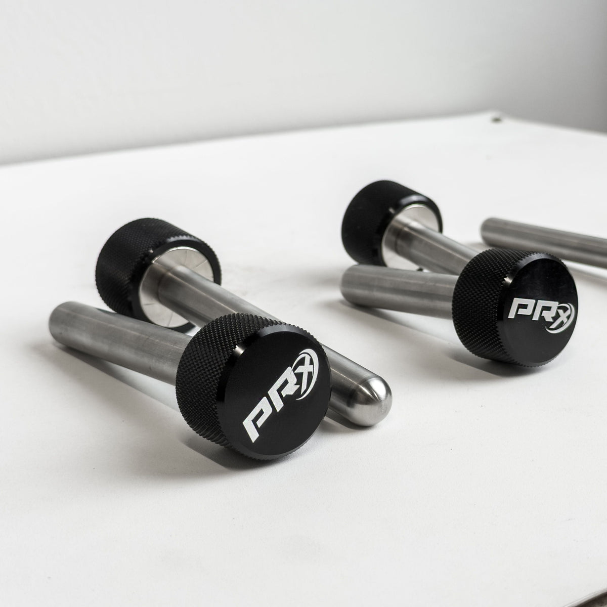Pair of PRx Mag Pins on a white surface with a gray background