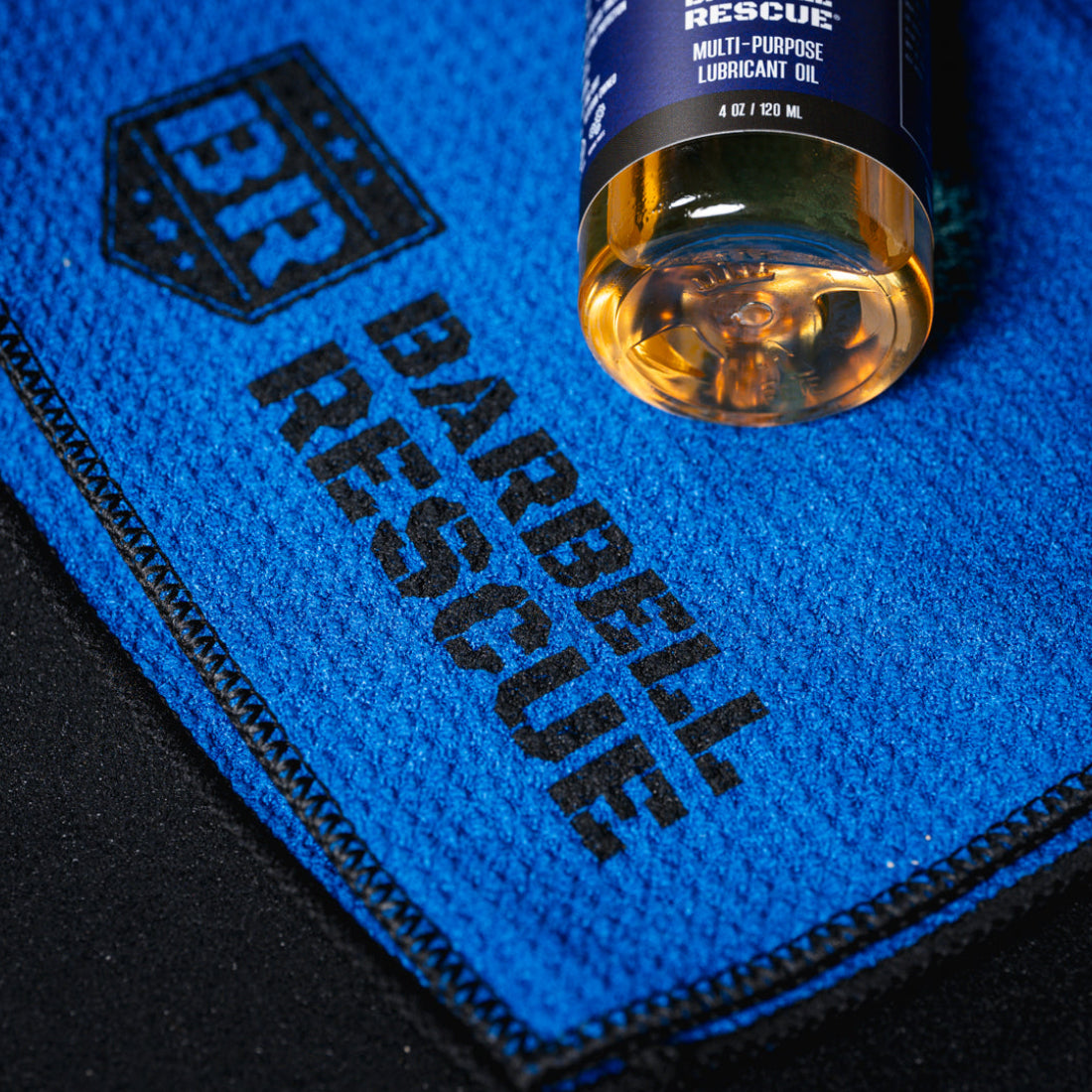 Barbell Rescue supplement bottle on a blue towel with 'BR' logo