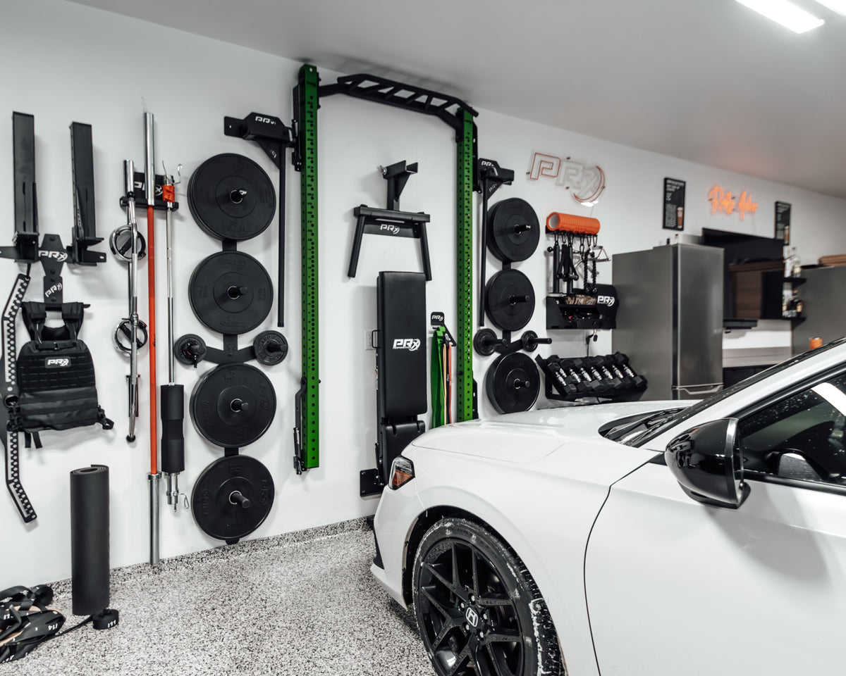 Garage interior with fitness equipment and a white car.