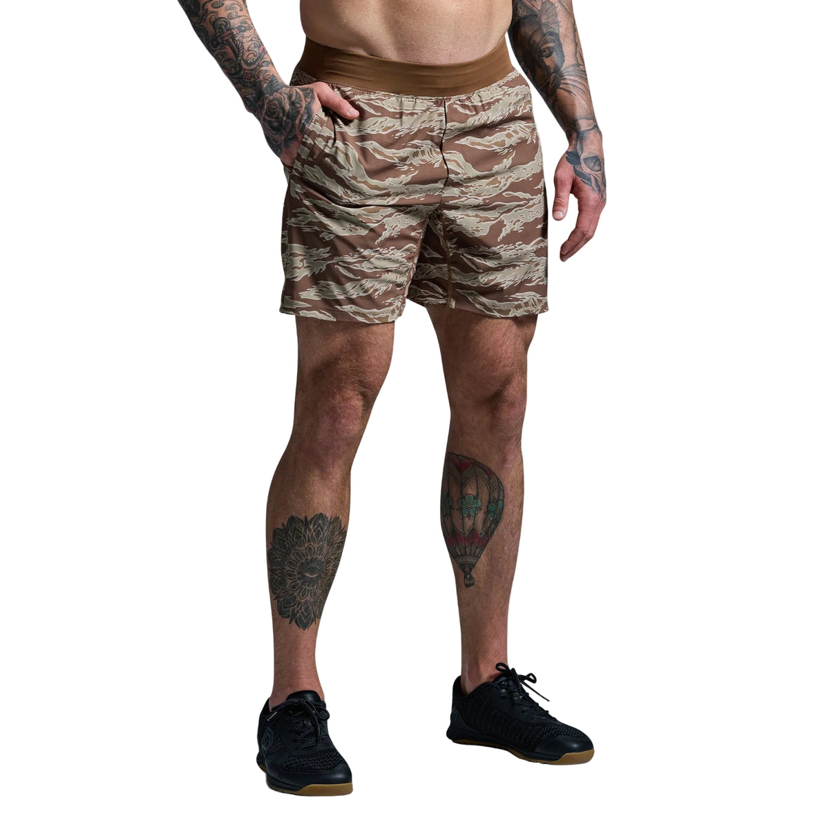 Person wearing camouflage shorts on a plain background