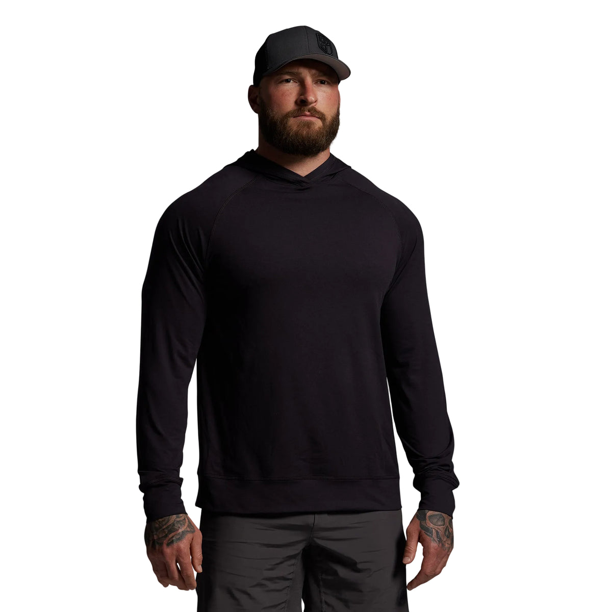 Man wearing a black hoodie and cap on a gray background