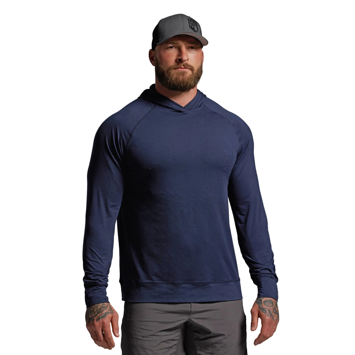 Man wearing a navy blue hoodie and gray cap on a light gray background