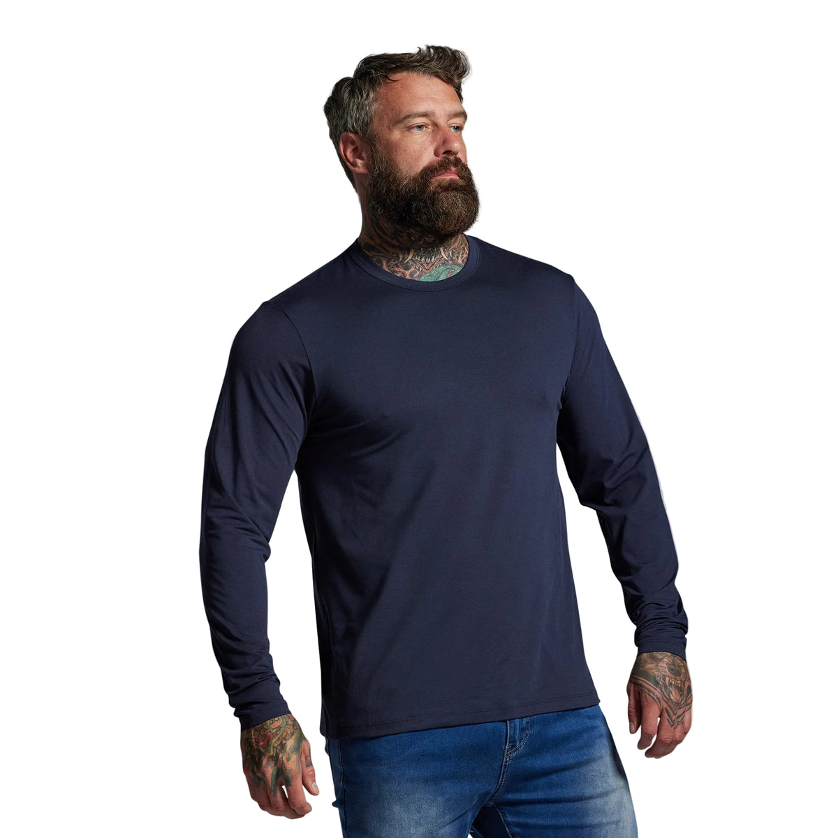 Man wearing a navy long-sleeve shirt and blue jeans against a gray background