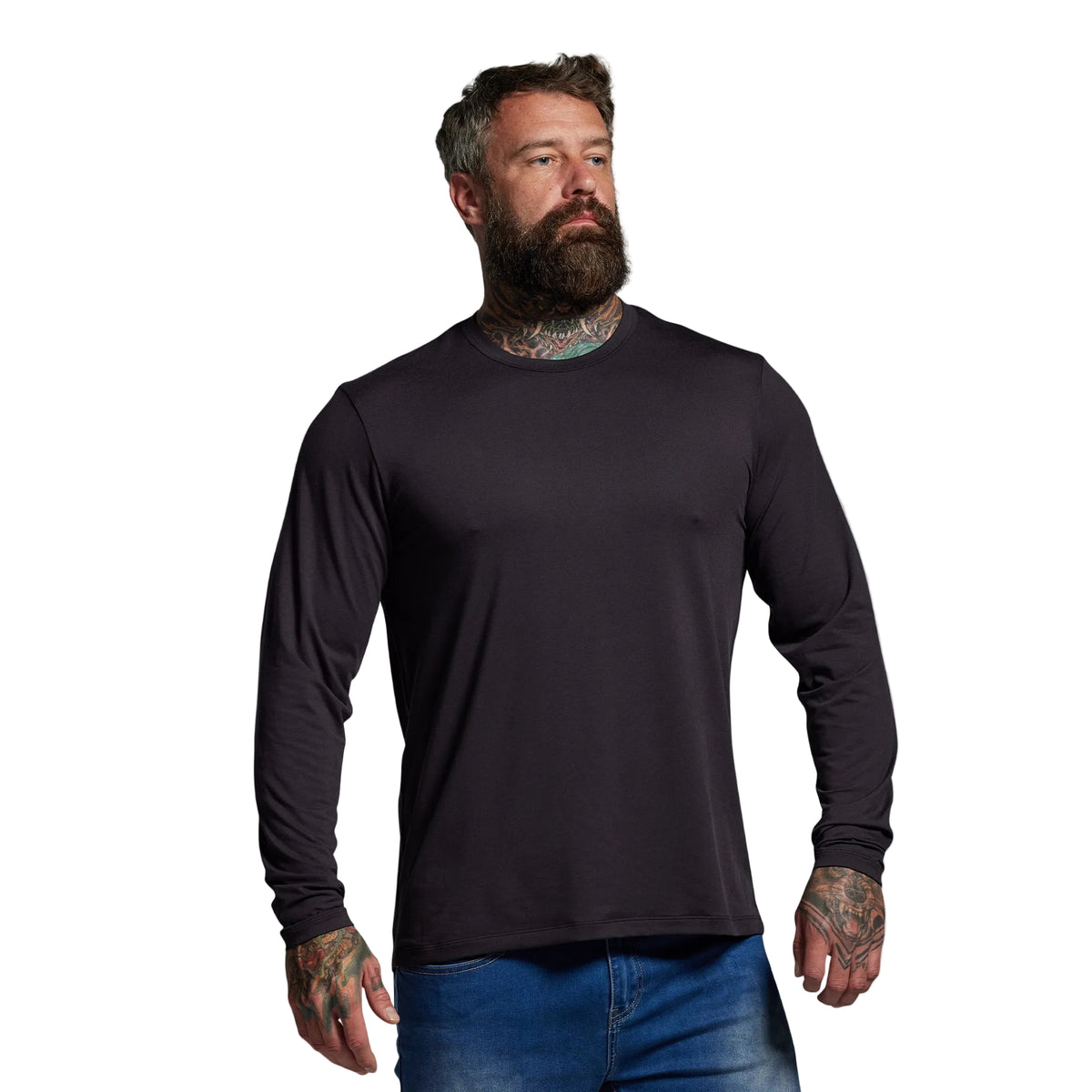 Man wearing a black long-sleeve shirt and blue jeans against a gray background