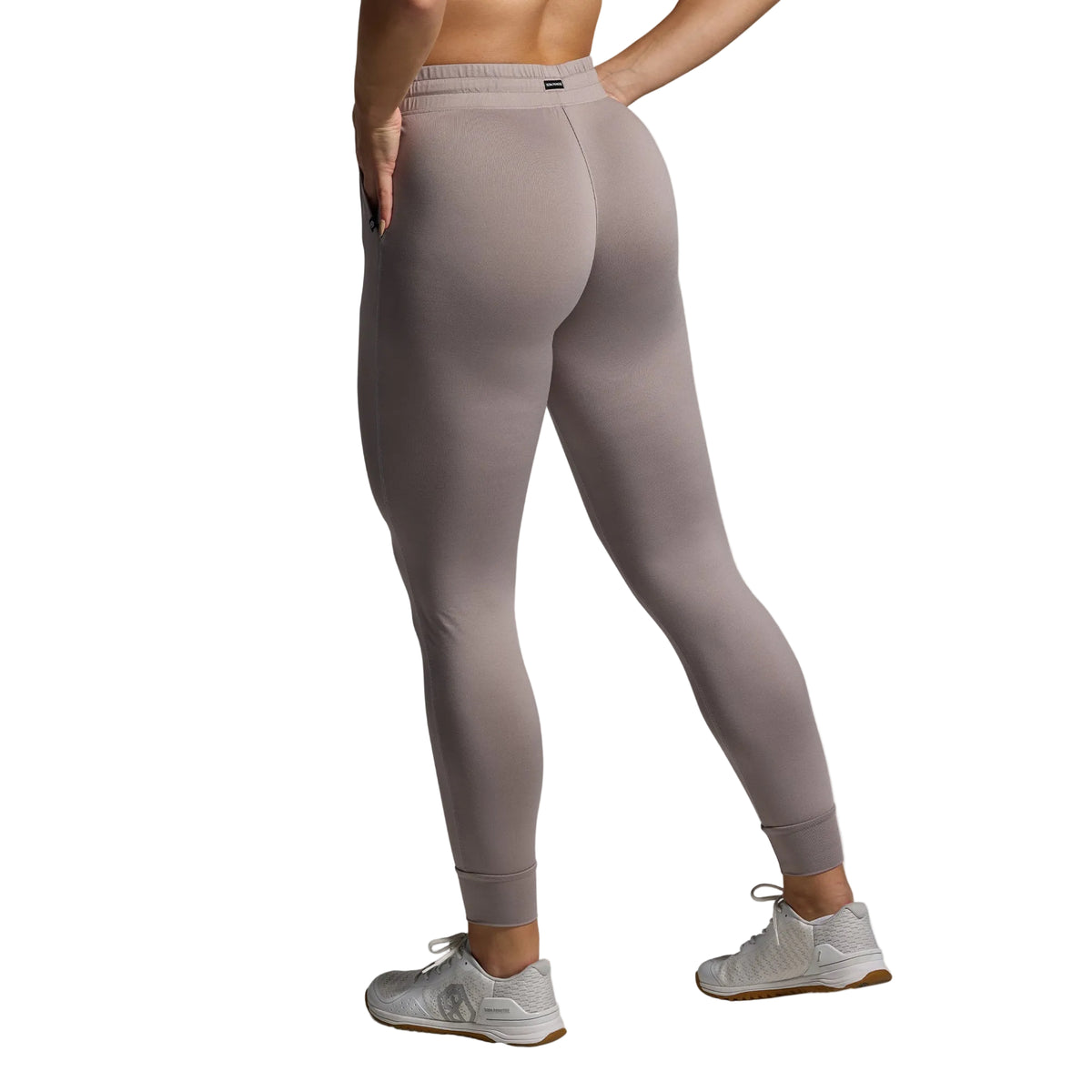 Person wearing beige leggings on a gray background