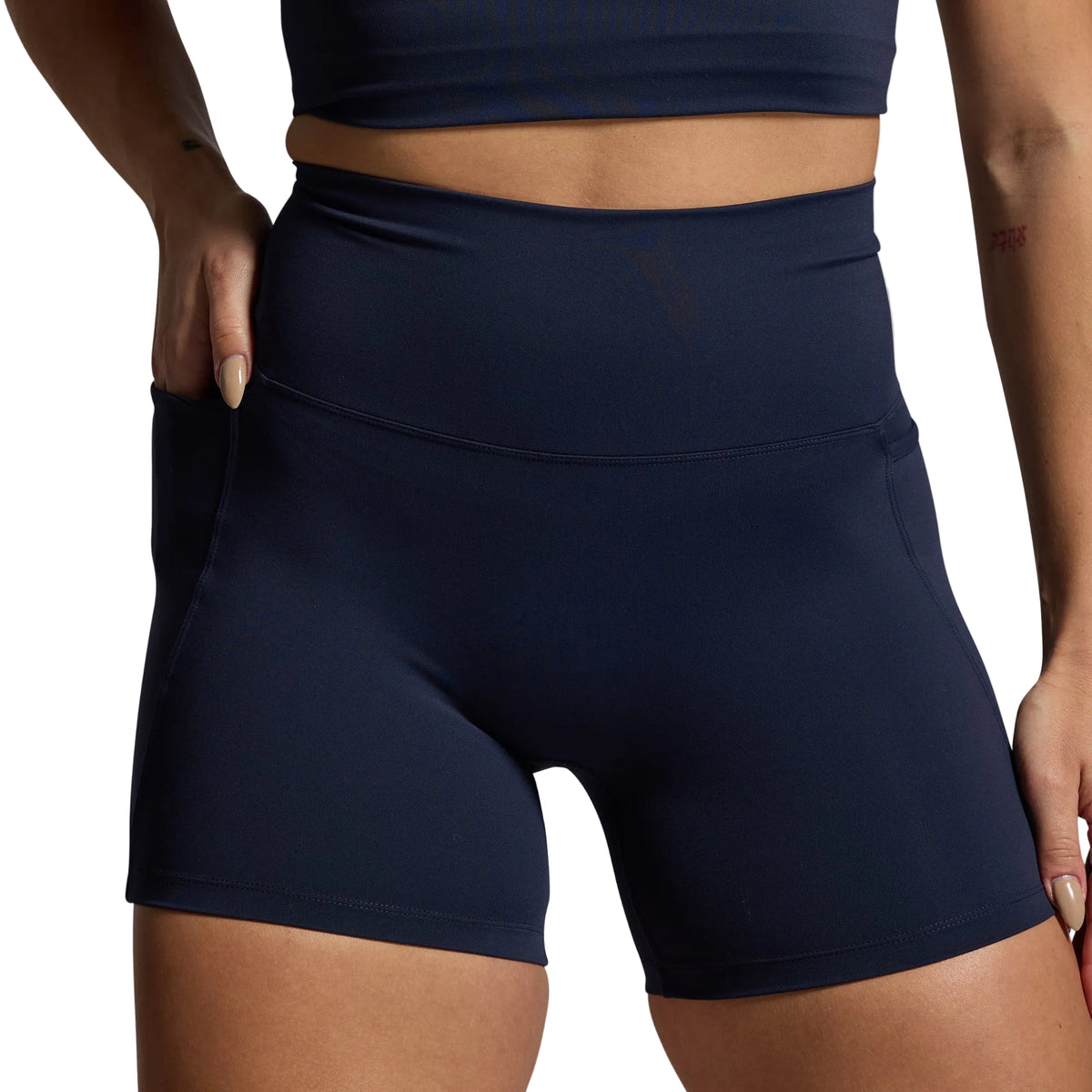Navy blue athletic shorts worn by a person on a gray background