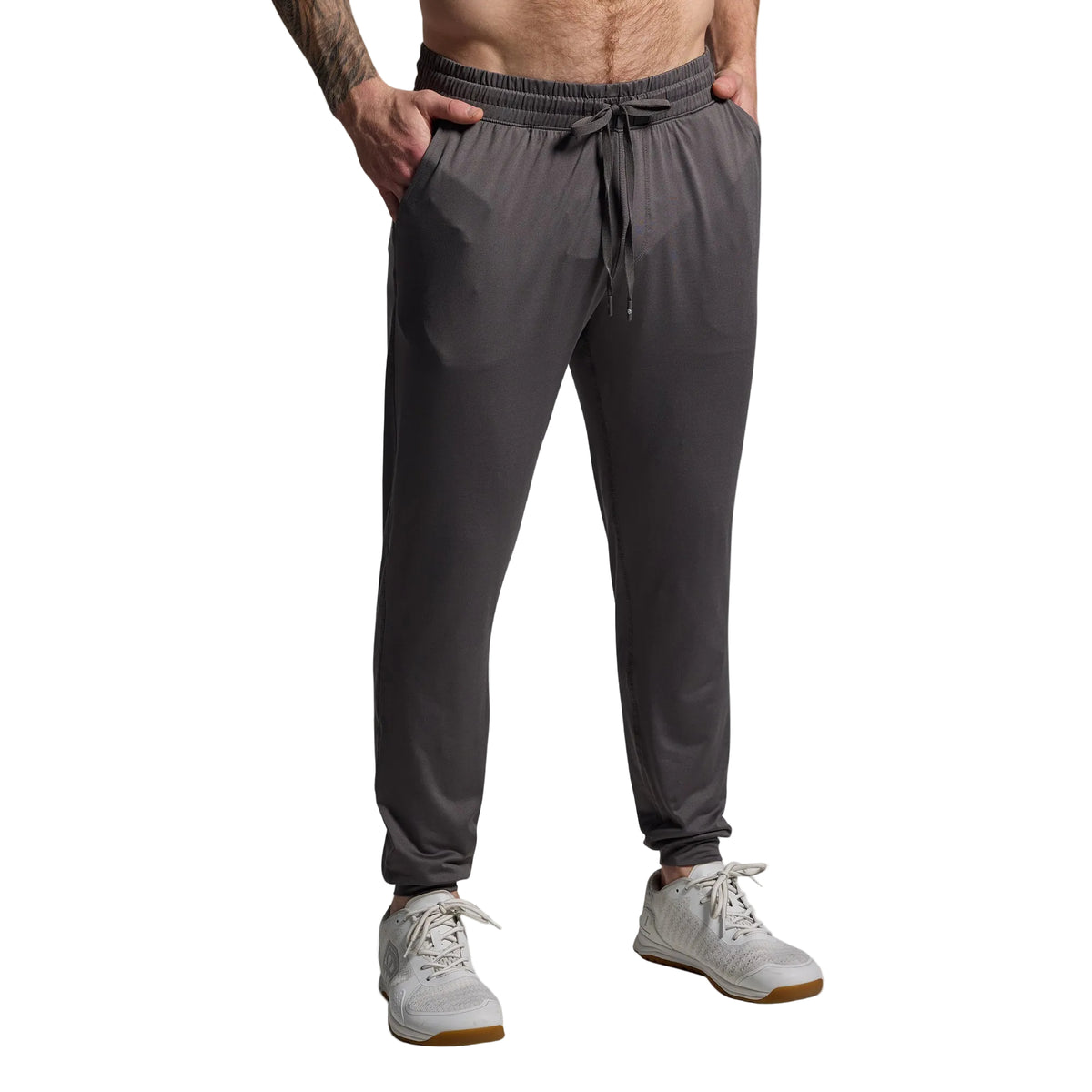 Person wearing gray jogger pants on a plain background