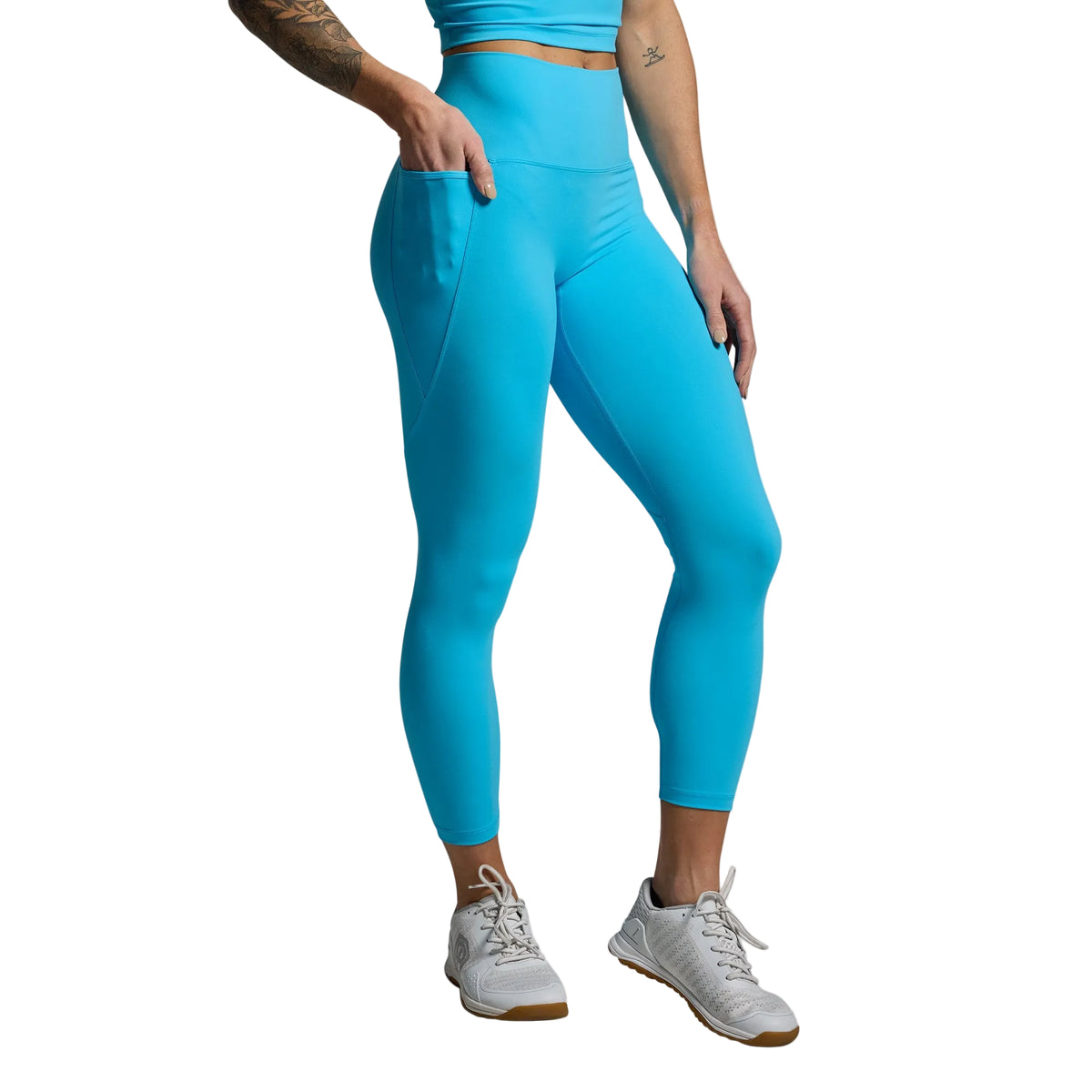 Person wearing bright blue leggings on a gray background