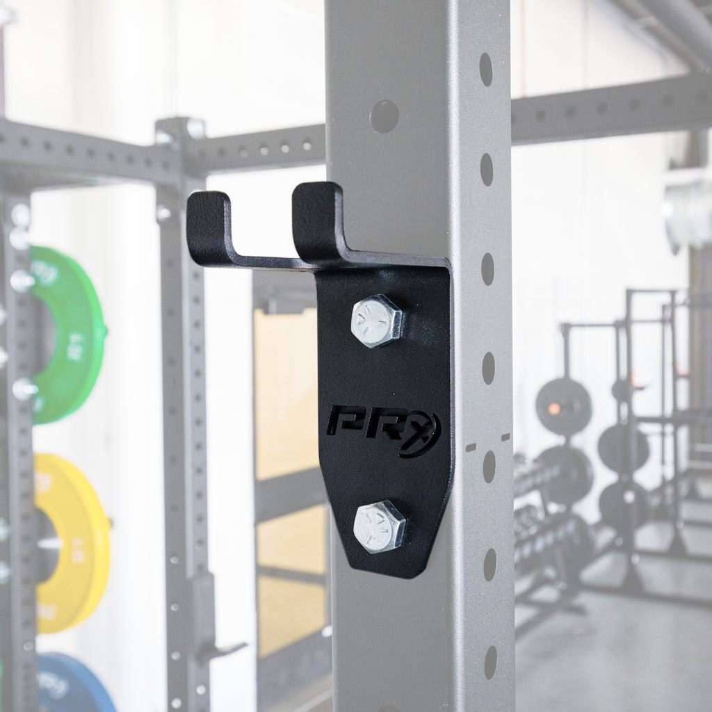 A black powder-coated barbell storage rack mount attached to a grey metal squat rack.