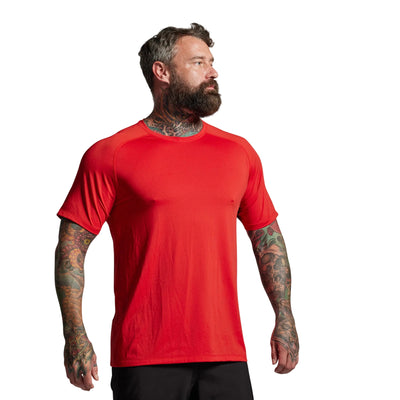 Man wearing a red t-shirt against a gray background
