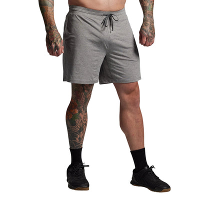 Person wearing gray shorts on a plain background