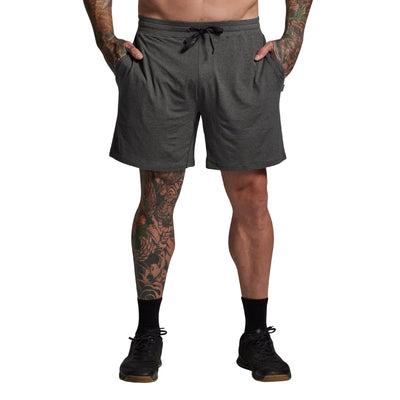Person wearing gray shorts on a plain background