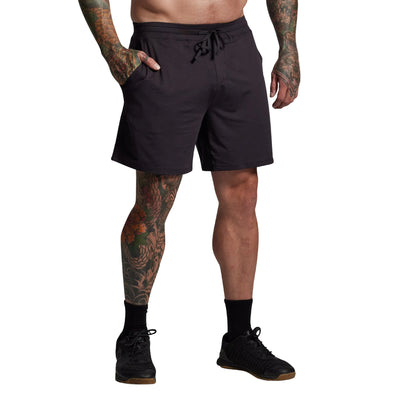 Person wearing black shorts on a gray background