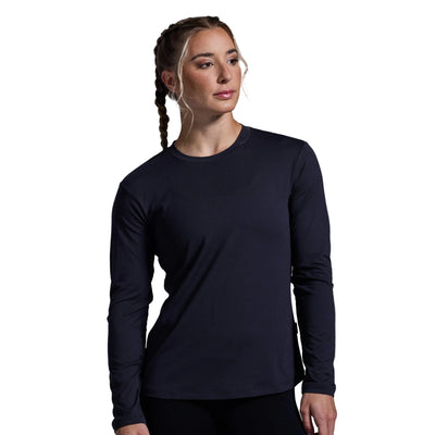 Woman wearing a black long-sleeve shirt against a gray background