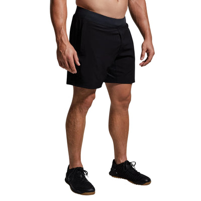 Person wearing black shorts on a gray background