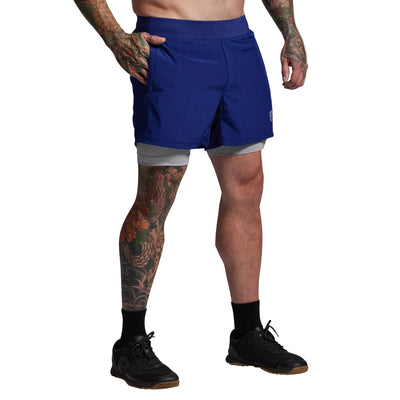 Person wearing blue athletic shorts on a gray background