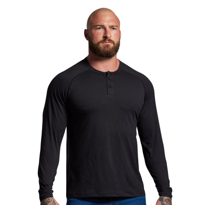 Man wearing a black long-sleeve shirt against a gray background