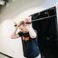 Man demonstrating overhead tricep press using resistance band handles connected to Door Mounted Pull-Up Bar.