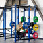 person squatting in front of storage shelves with weights stored