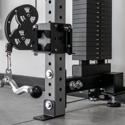 Weightlifting equipment with pulleys and weight plates on a gym floor.
