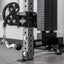 Weightlifting equipment with pulleys and weight plates on a gym floor.