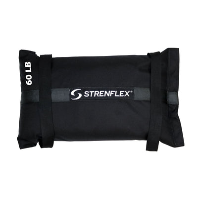 A black STRENFLEX sandbag weight with a 60 lb capacity label, featuring a central brand logo and adjustable straps, shown against a plain white background.