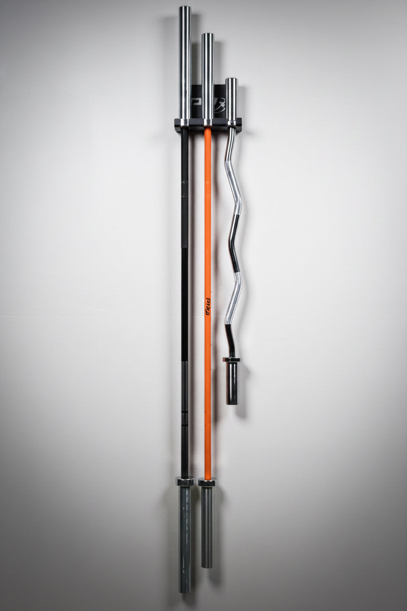 A wall-mounted vertical rack holding three barbell handles: two black with silver ends and one orange-and-black, shown against a plain light gray wall.