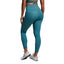 Person wearing teal leggings and a sports bra on a gray background