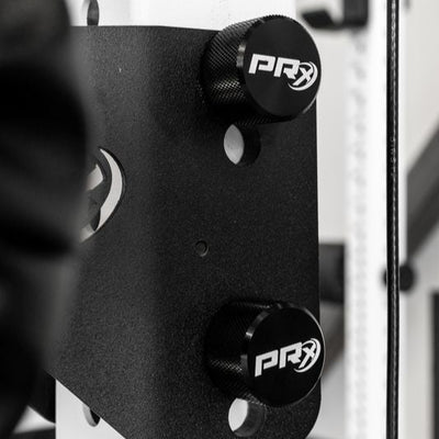 Black PRx weightlifting attachments on a white rack