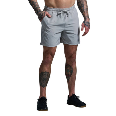 Person wearing light gray shorts on a plain background