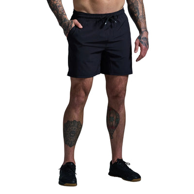 Person wearing black shorts on a gray background