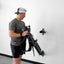 Person using a piece of exercise equipment against a white wall.