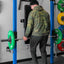 Person lifting a barbell with green and red weight plates in a gym setting