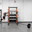 Person performing dips on a dip station in a gym setting with weights and exercise equipment.