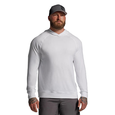 Man wearing a white long-sleeve shirt and gray cap on a gray background