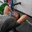 Person performing a bench press with weights in a gym setting