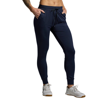 Person wearing navy jogger pants on a gray background