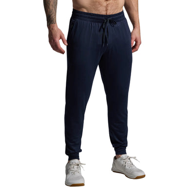 Person wearing navy jogger pants on a gray background