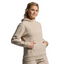 Woman wearing a beige hoodie against a plain background