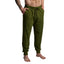 Green sweatpants worn by a person on a gray background
