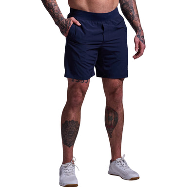 Person wearing navy athletic shorts on a plain background