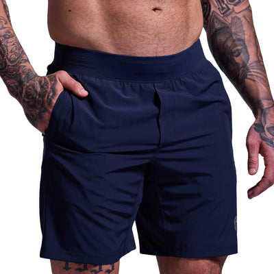 Navy blue shorts worn by a person with tattoos on a light gray background