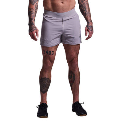 Person wearing light gray athletic shorts on a plain background