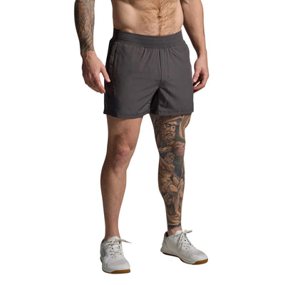 Man wearing gray shorts on a plain background