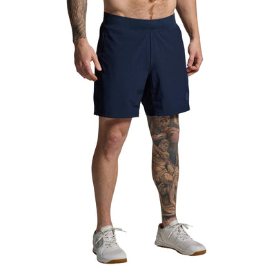 Person wearing navy shorts on a gray background