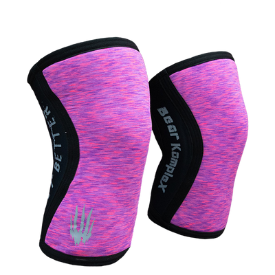 Pair of pink and black knee sleeves with 'Bear Komplex' branding on a white background
