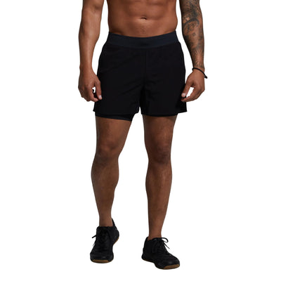 Person wearing black athletic shorts on a gray background