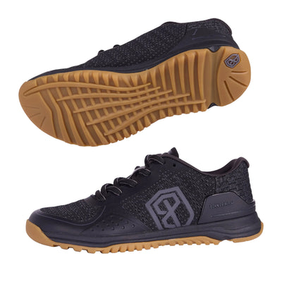 Black athletic shoe with brown sole on a gray background