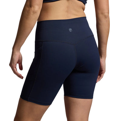 Navy blue athletic shorts worn by a person on a gray background
