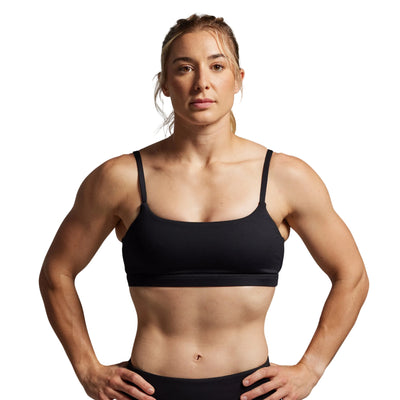 Woman wearing a black sports bra against a gray background
